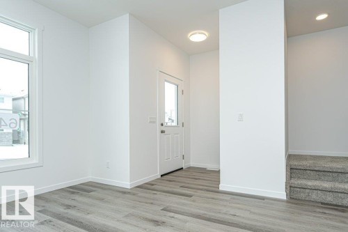 Entryway featuring wood-finish flooring, white trim, a multi-pane door with privacy glass, a flush-mount ceiling light, and a window - 6269 175A Avenue Nw, Edmonton, AB - Indoor Photo Showing Other Room