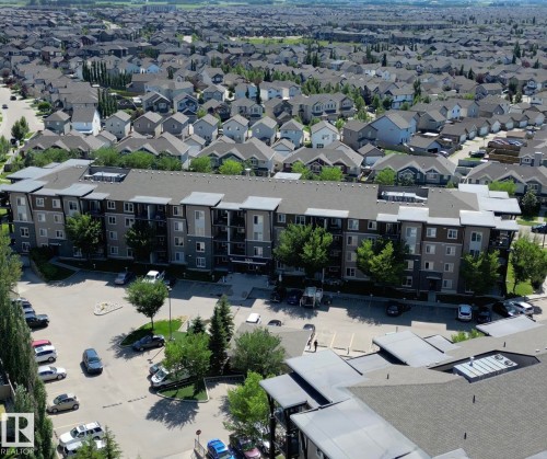 Multi-story residential building featuring a combination of light and dark grey siding - #107 530 Watt Bv Sw, Edmonton, AB - Outdoor With View