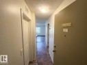 Entry foyer featuring tiled flooring, an overhead flush-mount light fixture, and textured ceilings - #107 530 Watt Bv Sw, Edmonton, AB  - Indoor Photo Showing Other Room 