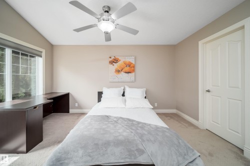 Recessed window with a built-in corner desk unit, neutral-toned walls, and a ceiling fan with integrated lighting - 11342 79 Avenue, Edmonton, AB - Indoor Photo Showing Bedroom