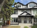 Contemporary duplex exterior featuring light-colored siding, dark trim, stone accents, and multiple large windows - 11342 79 Avenue, Edmonton, AB  - Outdoor With Facade 