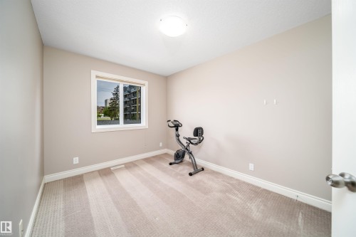 Neutral-toned room featuring a single window with white trim, light beige carpet flooring, and white baseboards - 11342 79 Avenue, Edmonton, AB - Indoor Photo Showing Gym Room
