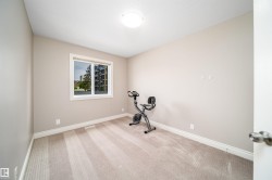 Neutral-toned room featuring a single window with white trim, light beige carpet flooring, and white baseboards - 