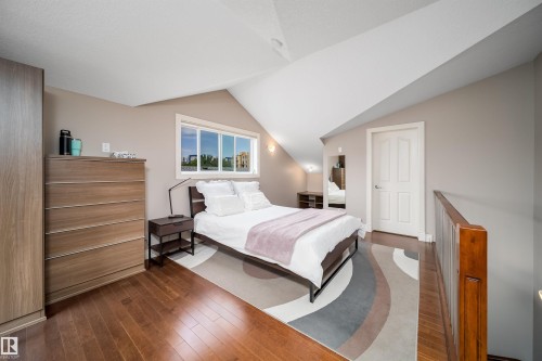 Bedroom featuring rich wood-finish flooring and a white paneled door - 11342 79 Avenue, Edmonton, AB - Indoor Photo Showing Bedroom