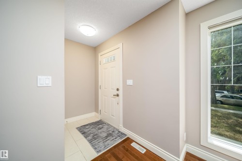 Entryway featuring a white paneled door with transom windows, a large window with white trim, and a flush mount ceiling light - 11342 79 Avenue, Edmonton, AB - Indoor Photo Showing Other Room