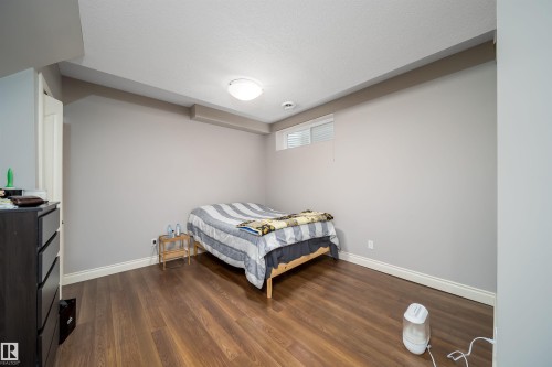 Spacious room with wood-finish flooring, light gray walls, and white trim - 11342 79 Avenue, Edmonton, AB - Indoor Photo Showing Bedroom
