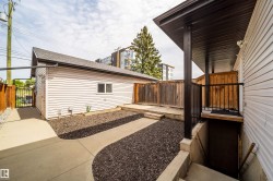 Detached garage with horizontal white siding and a sloped shingle roof - 