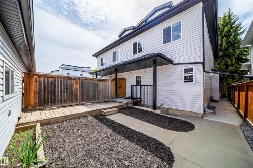 Exterior featuring light-colored siding, black trim, and a covered entryway - 11342 79 Avenue, Edmonton, AB - Outdoor With Exterior
