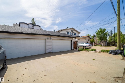 Detached two-car garage with white paneled doors and exterior wall lighting - 11342 79 Avenue, Edmonton, AB - Outdoor