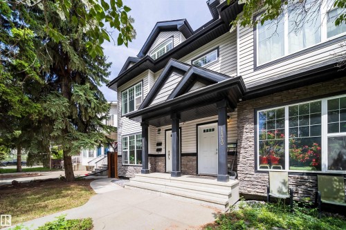 Multi-level facade featuring light siding and stone veneer accents - 11342 79 Avenue, Edmonton, AB - Outdoor With Facade