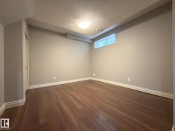 Wood-finish flooring, recessed lighting, and a white trim package - 