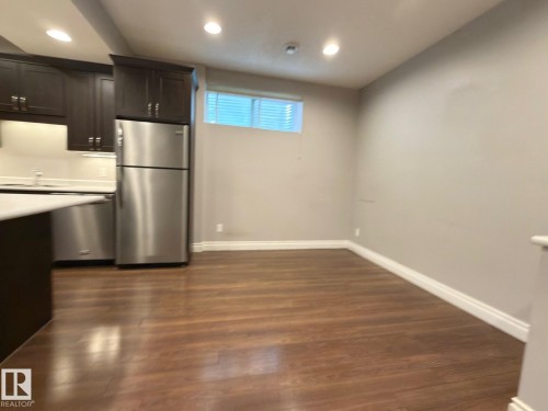 Wood-finish flooring throughout - 11342 79 Avenue Nw, Edmonton, AB - Indoor Photo Showing Other Room
