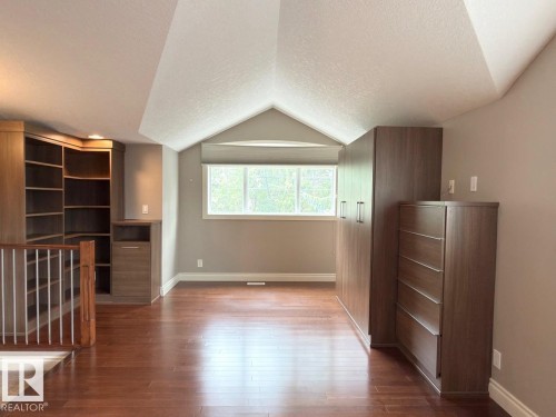 Wood-finish flooring with built-in cabinetry, shelving, and storage units - 11342 79 Avenue Nw, Edmonton, AB - Indoor Photo Showing Other Room