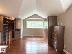 Wood-finish flooring with built-in cabinetry, shelving, and storage units - 