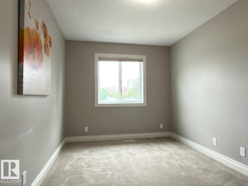Carpeted room with a double-paned window, neutral wall tones, and white trim - 11342 79 Avenue Nw, Edmonton, AB - Indoor Photo Showing Other Room
