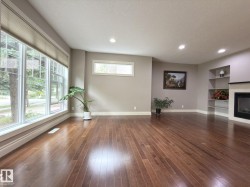 Hardwood flooring, recessed lighting, large bay windows, built-in shelving, and a fireplace with a mantel - 