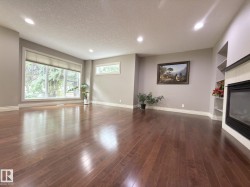 Spacious room featuring wood-finish flooring, recessed lighting, and a large window with roller shades - 