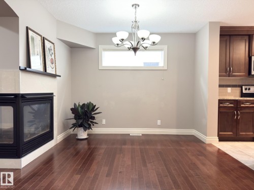 Corner fireplace with a light-toned surround - 11342 79 Avenue Nw, Edmonton, AB - Indoor With Fireplace
