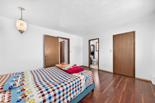 Spacious room featuring wood-finish flooring, white walls, and a textured white ceiling - 1928 68 Street Nw, Edmonton, AB - Indoor Photo Showing Bedroom