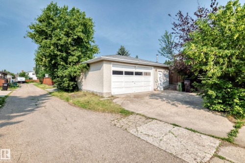 Detached garage featuring a white overhead door and an additional side entry door - 1928 68 Street Nw, Edmonton, AB - Outdoor