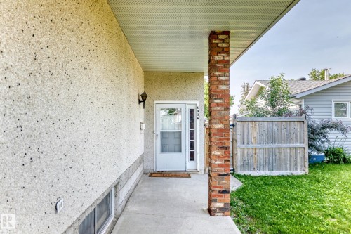 Welcoming covered entry featuring a brick pillar and stucco exterior - 1928 68 Street Nw, Edmonton, AB - Outdoor