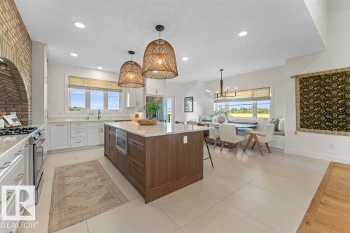 Open-concept kitchen and dining area featuring a central island with built-in appliances, light-toned quartz countertops, and recessed lighting - 2503 Lockhart Way, Cold Lake, AB - Indoor Photo Showing Kitchen With Upgraded Kitchen