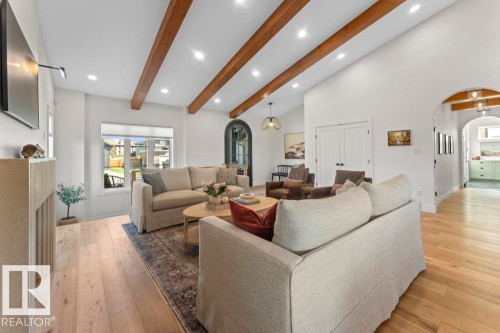 Spacious living area featuring vaulted ceilings with exposed wood beams, lighting, and hardwood flooring - 2503 Lockhart Way, Cold Lake, AB - Indoor Photo Showing Living Room