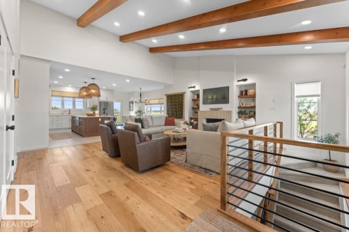 Open-concept living space featuring exposed wood ceiling beams, lighting, and hardwood flooring - 2503 Lockhart Way, Cold Lake, AB - Indoor Photo Showing Other Room