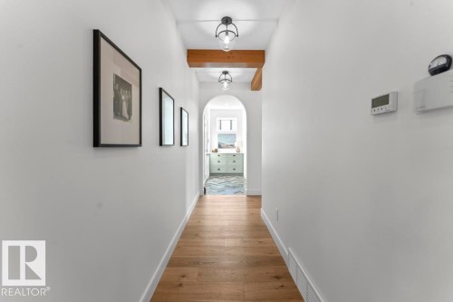 Hallway featuring hardwood flooring, white walls, and lighting with black metal accents - 2503 Lockhart Way, Cold Lake, AB - Indoor Photo Showing Other Room