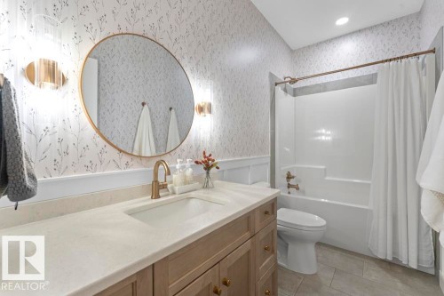 Single vanity featuring a built-in sink, light-toned countertop, and wood-finish cabinetry - 2503 Lockhart Way, Cold Lake, AB - Indoor Photo Showing Bathroom