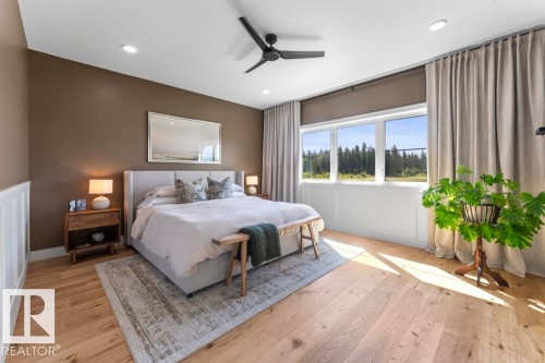 Bedroom featuring expansive windows, wood-finish flooring, recessed lighting, a ceiling fan, and wainscoting - 2503 Lockhart Way, Cold Lake, AB - Indoor Photo Showing Bedroom