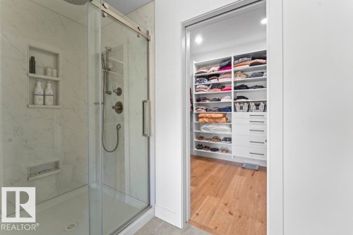 Glass-enclosed shower with porcelain tile, brushed nickel fixtures, and recessed shelving - 2503 Lockhart Way, Cold Lake, AB - Indoor Photo Showing Bathroom