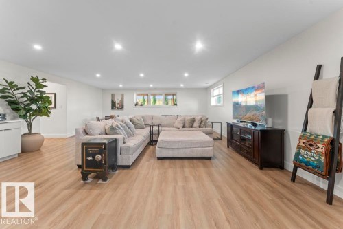 Spacious lower-level living area featuring wood-finish flooring, recessed lighting, and white baseboards - 2503 Lockhart Way, Cold Lake, AB - Indoor