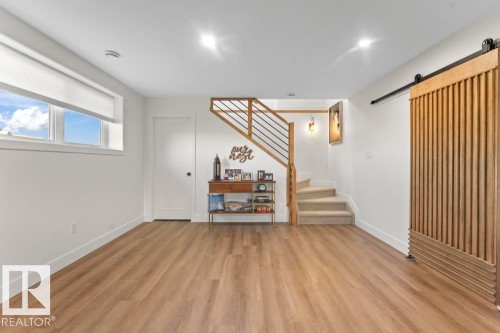 Open floor plan featuring wood-finish flooring and white walls - 2503 Lockhart Way, Cold Lake, AB - Indoor Photo Showing Other Room