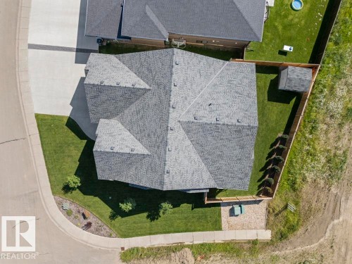 Aerial perspective showcasing a property with a multi-gabled roofline, a concrete driveway, a manicured lawn, a wood fence, and an outdoor storage shed - 2503 Lockhart Way, Cold Lake, AB - Outdoor