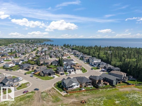 Residential community featuring established homes and new construction, bordered by a substantial body of water and dense evergreen forest - 2503 Lockhart Way, Cold Lake, AB - Outdoor With Body Of Water With View