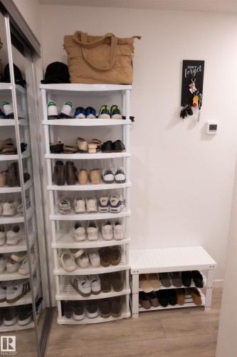 Wood-finish flooring with white wall finishes - #103 860 Secord Bv Nw, Edmonton, AB - Indoor Photo Showing Other Room
