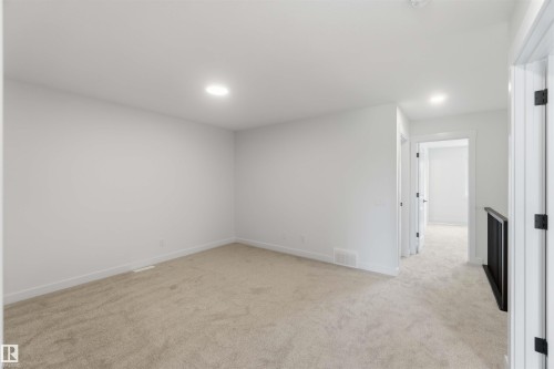 Carpeted room featuring recessed ceiling lighting, light-toned wall paint, white baseboards, and a white ceiling - 5872 Raven Crescent Nw, Edmonton, AB - Indoor Photo Showing Other Room
