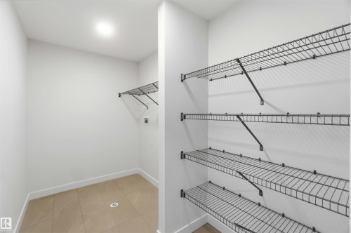 Utility room with tile flooring, white walls, overhead lighting, and wire shelving - 5872 Raven Crescent Nw, Edmonton, AB - Indoor With Storage