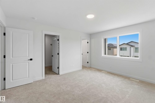 Spacious room featuring light-colored carpeting, white trim, and white walls - 5872 Raven Crescent Nw, Edmonton, AB - Indoor Photo Showing Other Room
