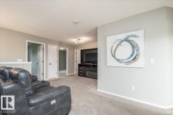 Carpeted room featuring light gray walls, white trim, and multiple doorways - 