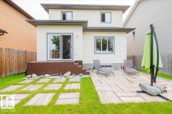 Rear exterior with a brown composite deck, sliding glass door access, and a patterned patio - 