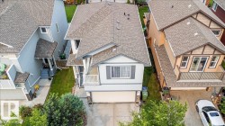 Two-story residence featuring a shingled roof, white siding, and an attached garage - 