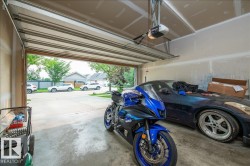 Attached garage with a concrete floor, automatic garage door opener, and finished drywall walls - 