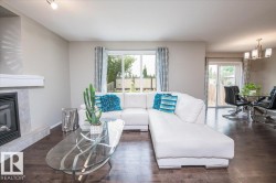 Living area featuring dark wood-finish flooring, a contemporary fireplace with a light-toned tile surround, and a white mantel - 