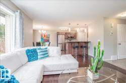 Open-concept living space featuring wood-finish flooring - 