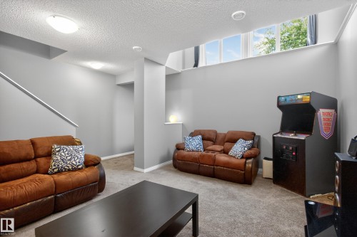 Spacious room with gray walls and carpeted flooring - 9847 220 Street Nw, Edmonton, AB - Indoor