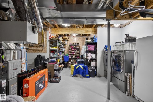 Utility area featuring exposed ceiling joists, ductwork, and a durable concrete floor - 9847 220 Street Nw, Edmonton, AB - Indoor Photo Showing Laundry Room