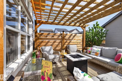 Outdoor wooden deck featuring a slatted pergola overhead with string lighting - 9847 220 Street Nw, Edmonton, AB - Outdoor With Deck Patio Veranda With Exterior