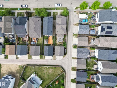Aerial perspective showcasing residential properties with a mix of asphalt shingle and solar panel rooftops - 9847 220 Street Nw, Edmonton, AB - Outdoor